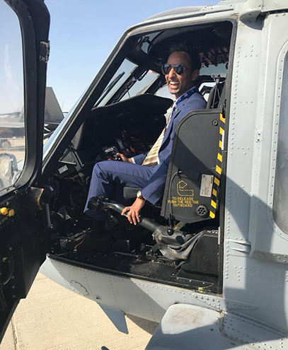 Kalim Rahim seated in a helicopter, smiling confidently